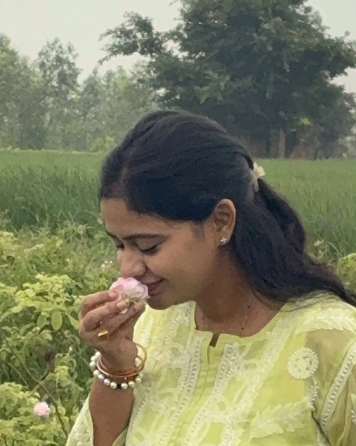 Salony Mittal smelling a Damask rose in a rose field